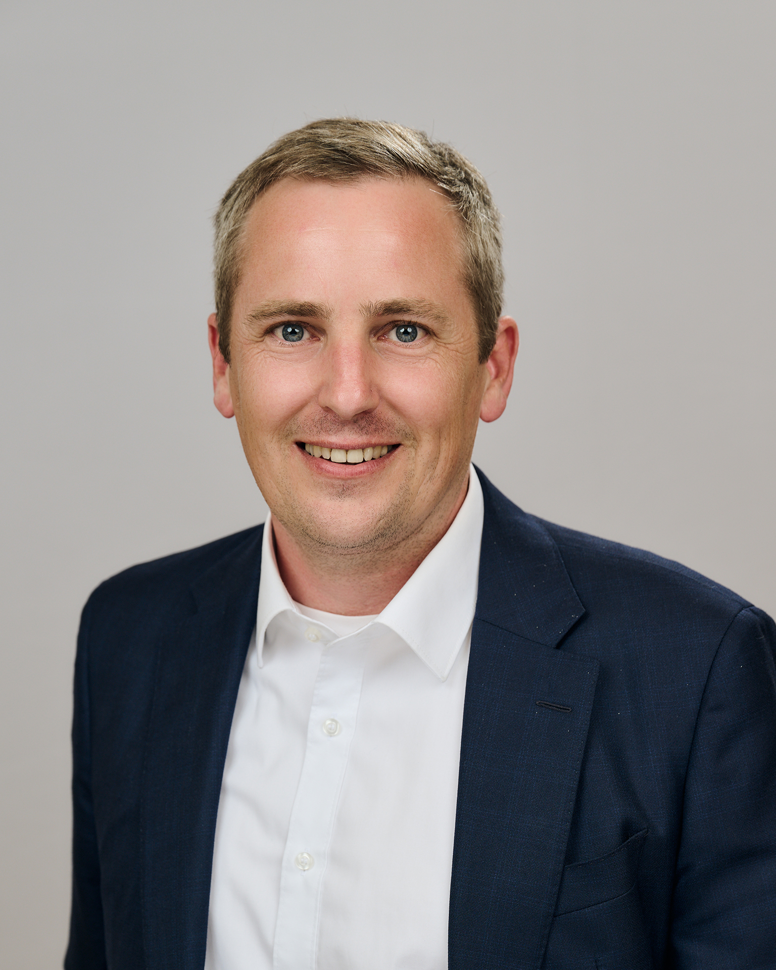 Porträt einer männlich gelesenen Person, vor einem hellen Hintergrund und blickt in die Kamera. Er trägt ein weißes Hemd und ein dunkles Sakko. Fotocredit: FH Gesundheitsberufe OÖ|Wiesler Porträt einer männlich gelesenen Person, vor einem hellen Hintergrund und blickt in die Kamera. Er trägt ein weißes Hemd und ein dunkles Sakko. Fotocredit: FH Gesundheitsberufe OÖ|Wiesler