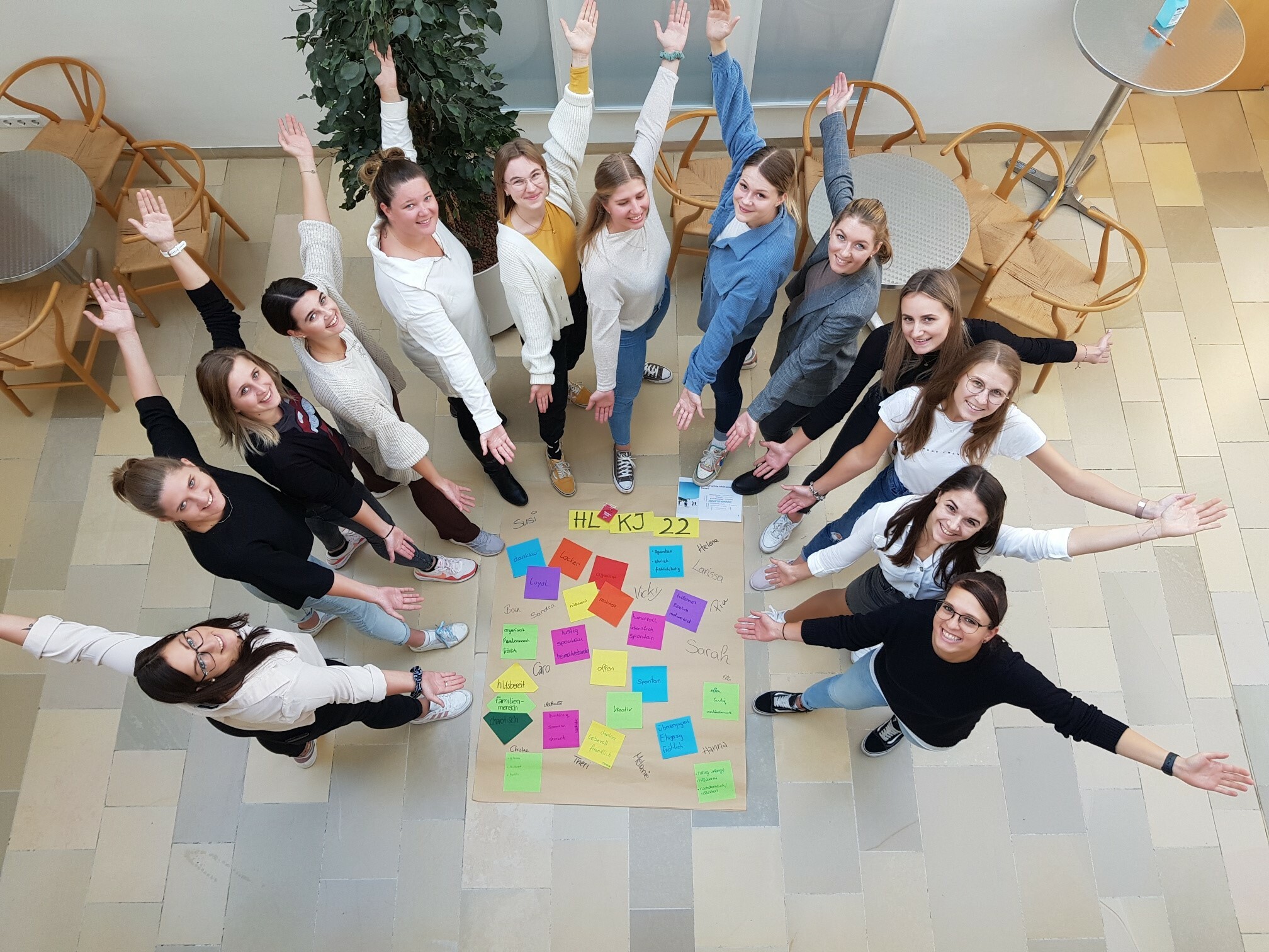 Gruppe mit Plakat und gestreckten Armen 