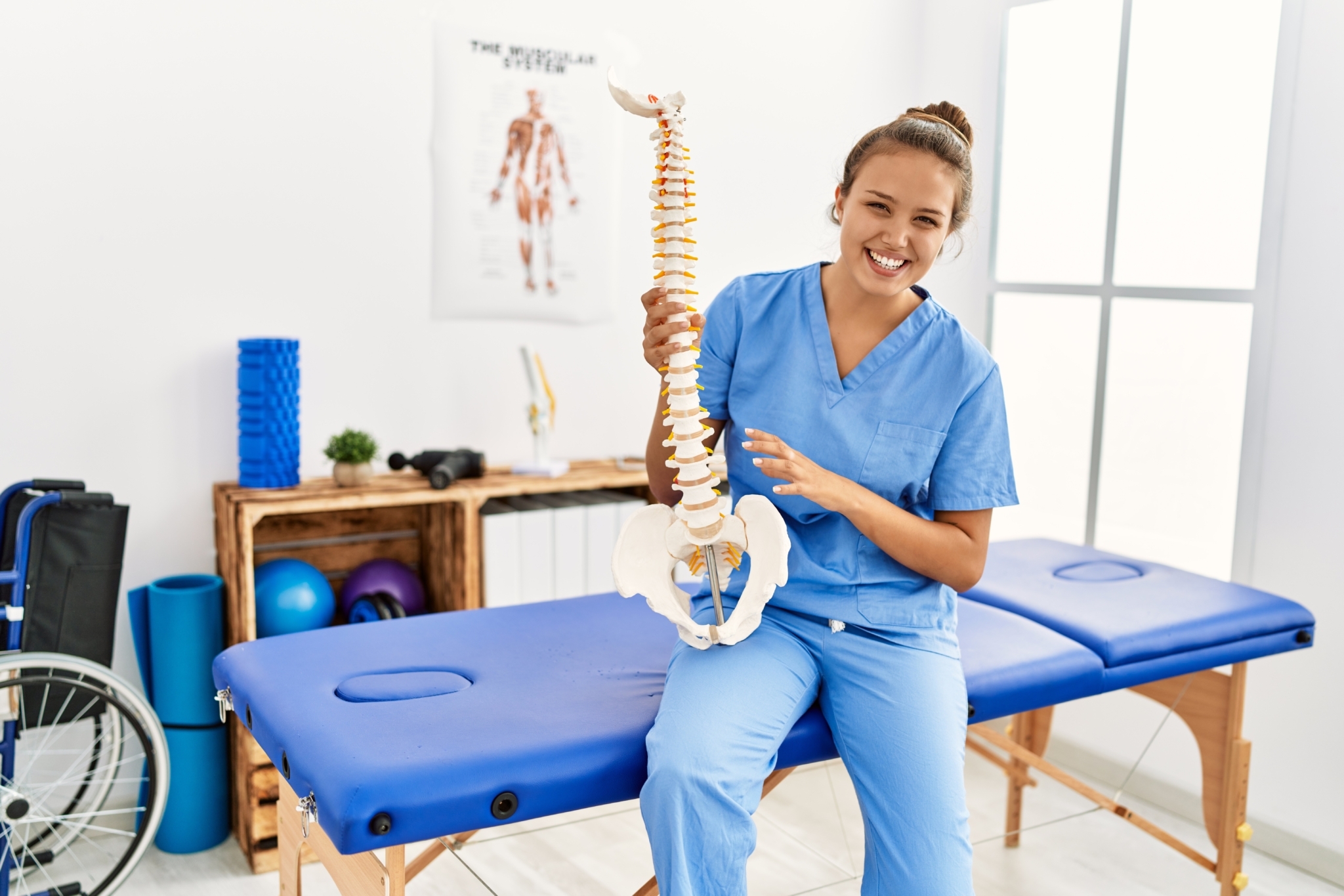 Physiotherapeutin erklärt lächelnd die Wirbelsäule, fotocredit: krakenimages com – stock.adobe.com Physiotherapeutin erklärt lächelnd die Wirbelsäule, fotocredit: krakenimages com – stock.adobe.com