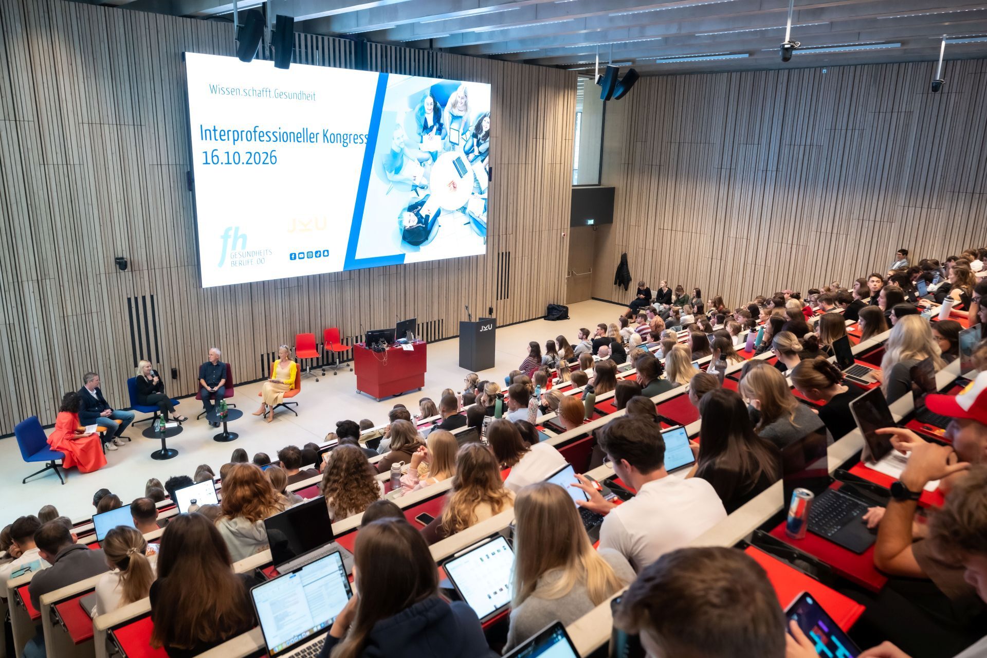 Ansicht vom vollbesetzten Hörsaal, Personen auf der Bühne in einer Talkrunde, fotocredit: JKU | röbl Ansicht vom vollbesetzten Hörsaal, Personen auf der Bühne in einer Talkrunde, fotocredit: JKU | röbl