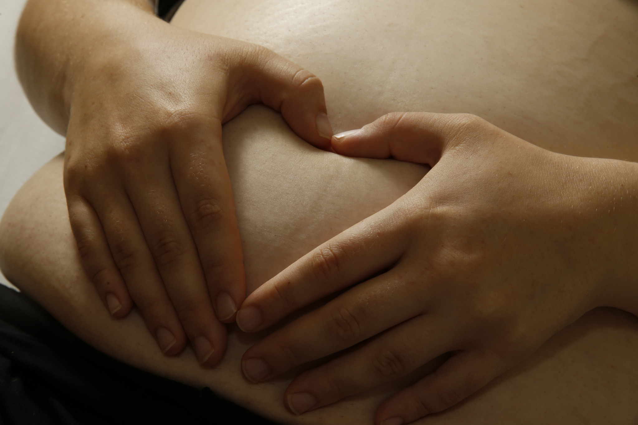Schwangere fühlt ihren Bauch (Fotocredit:  (vergrößerete Ansicht in der Galerie)