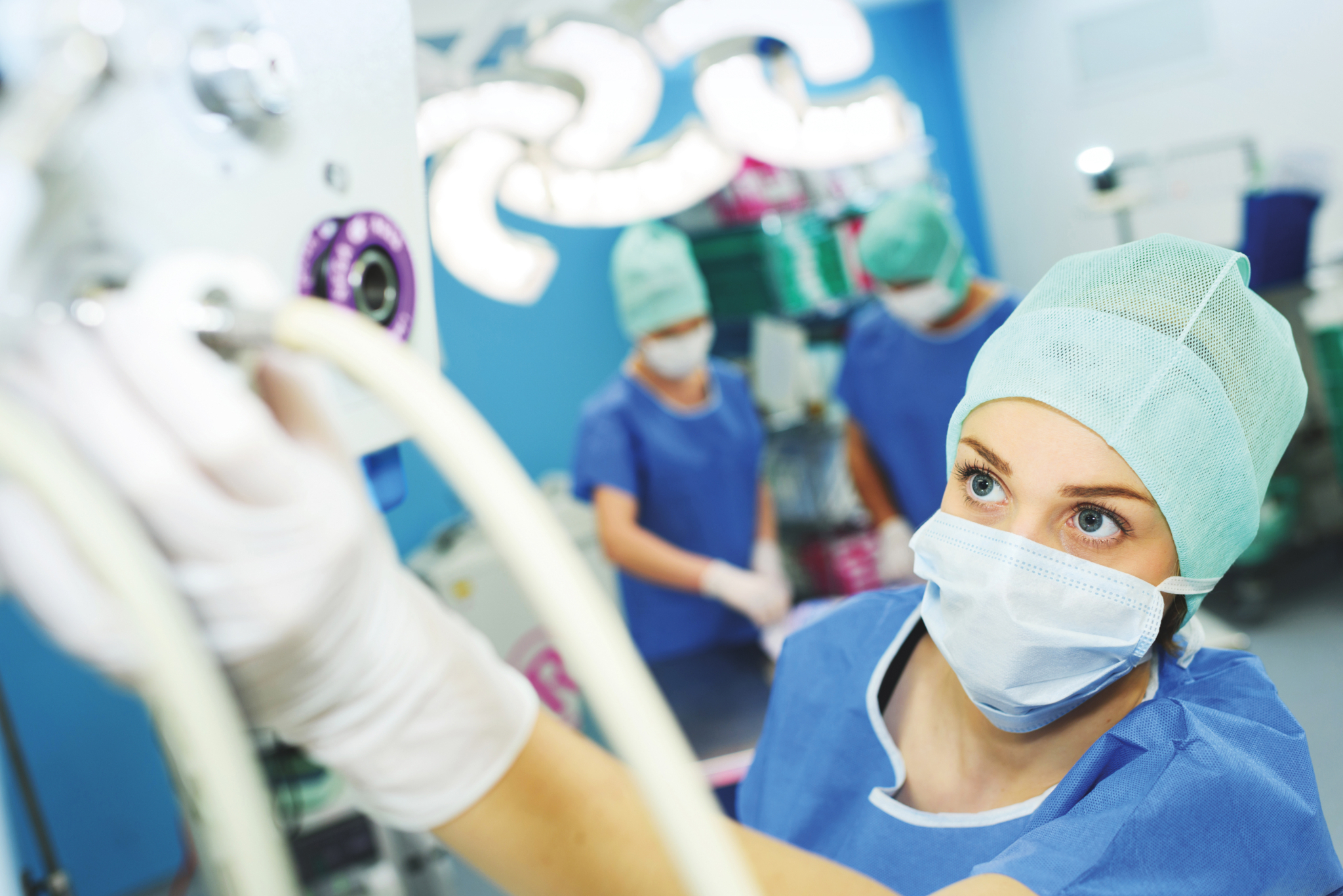 Anästhesiepfleger*in beim kontrollieren eines Gerätes Anästhesiepfleger*in beim kontrollieren eines Gerätes