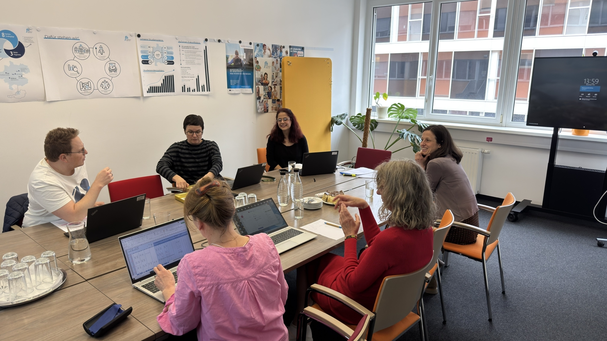 Teilnehmer*innen des Journal Club sitzend rund um einen Besprechungstisch 